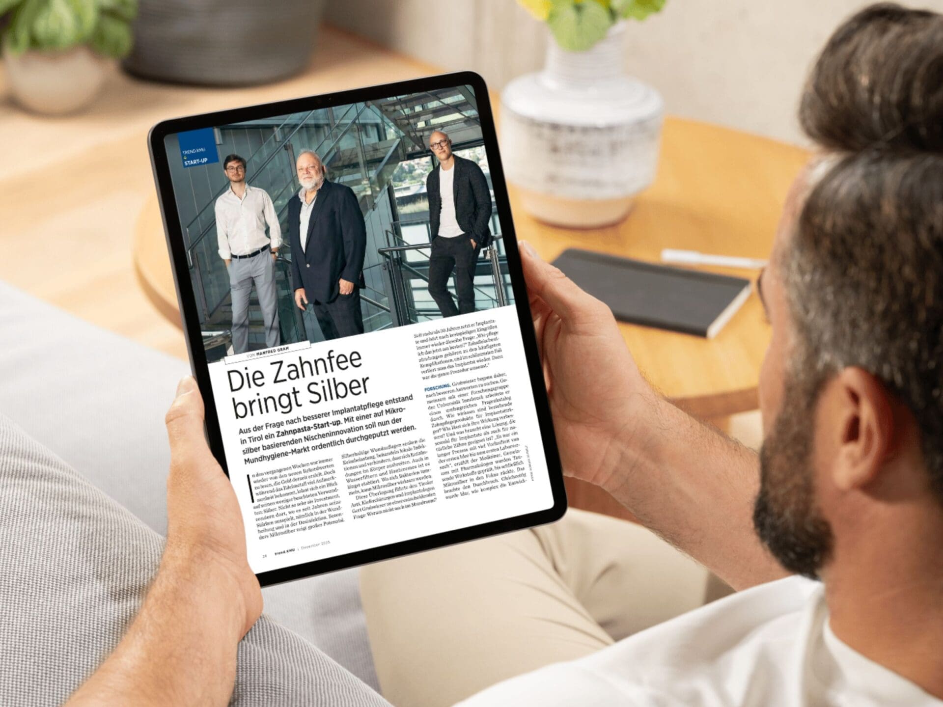 Mann liest Artikel über Improic auf einem Tablet